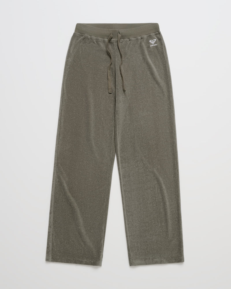 The ROXY x Madhappy Terry Lounge Pant in olive green velour features a drawstring waistband and a small embroidered heart logo on the left hip, shown laid flat on a white background.