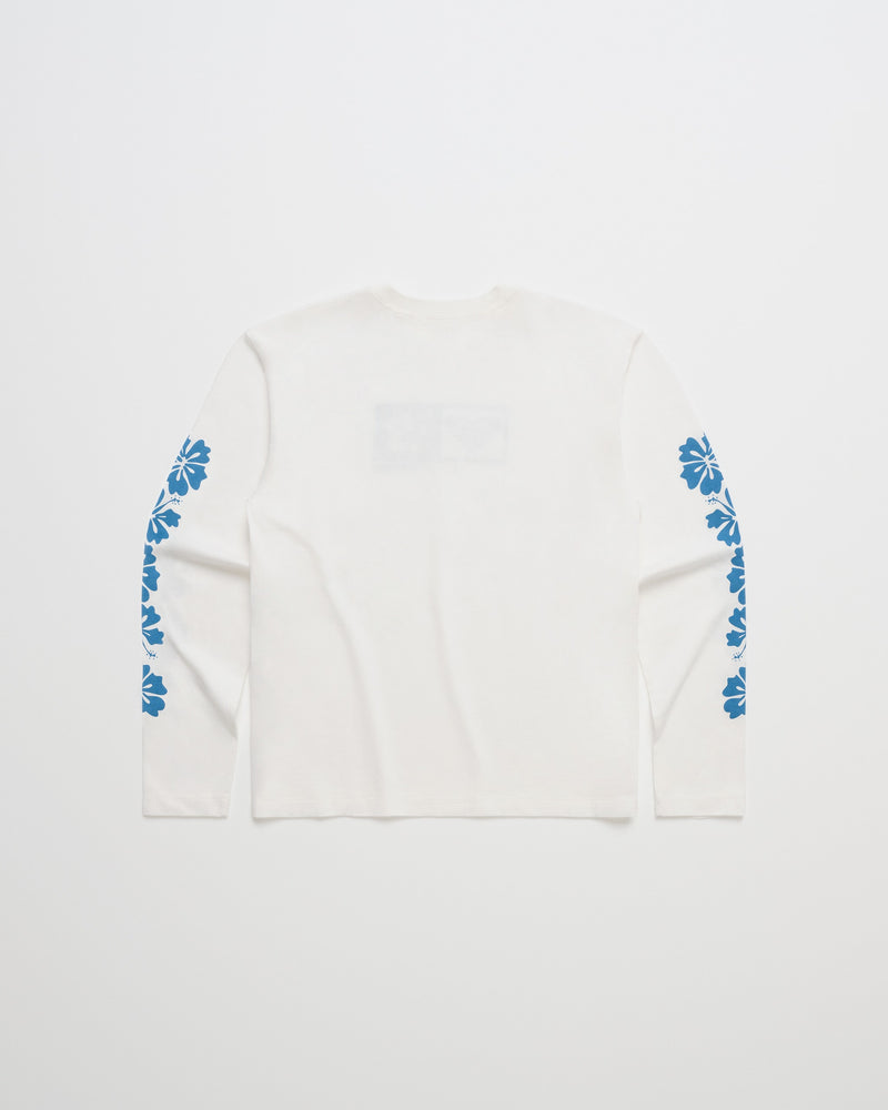 The ROXY x Madhappy Long Sleeve T-Shirt features a white design with blue floral graphics running down both sleeves. Displayed flat on a plain white background and viewed from the back, this versatile piece by Roxy x Madhappy is perfect for any casual wardrobe.