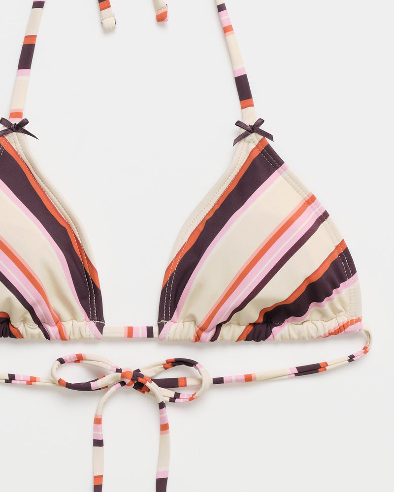 The Roxy x Madhappy Mini Tiki Triangle Bikini Top by Roxy features a vibrant multi-color stripe pattern in shades of purple, pink, orange, and cream. This women’s bikini top is designed with triangle cups, a stylish halter neck, and a tie closure at the front, displayed on a white background.