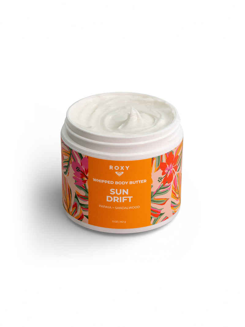 Roxy Sun Drift Body Butter features a creamy white formula with papaya and sandalwood, presented in a jar with an orange floral design—your daily go-to moisturizer for hydration and dry skin relief.