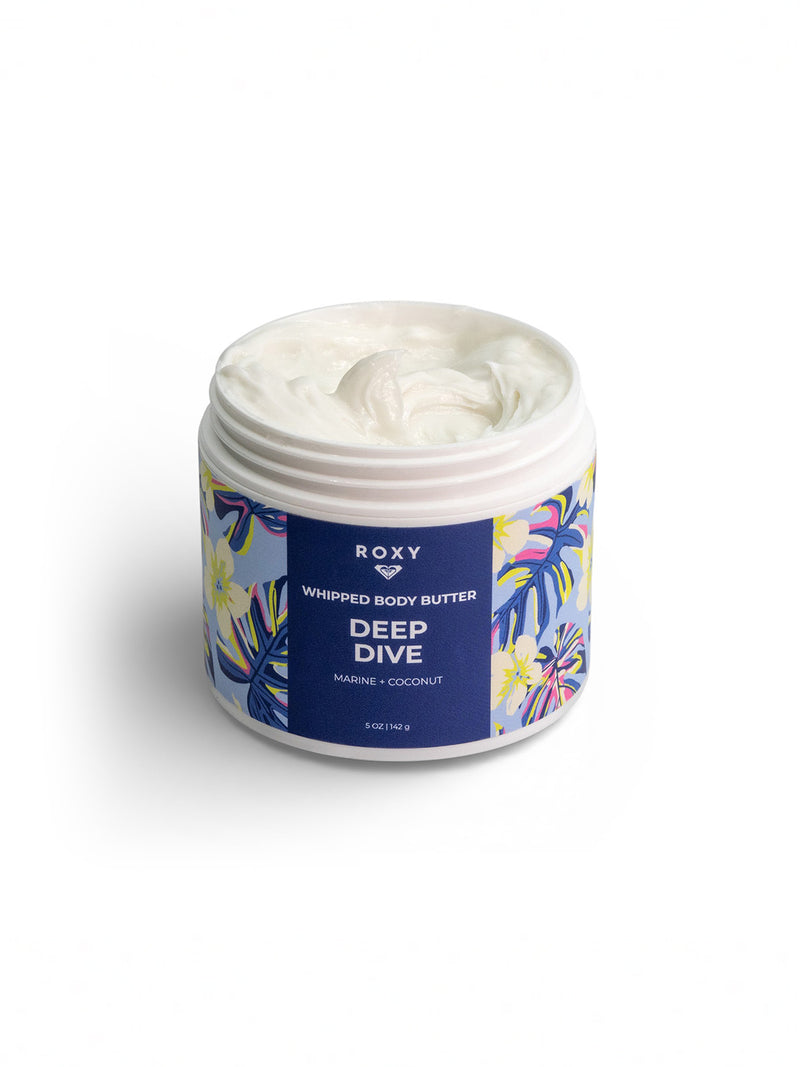 A jar of Roxy Deep Dive Body Butter with a blue label decorated with tropical flowers and leaves, shown open to reveal creamy white butter for deep hydration and a refreshing marine scent.