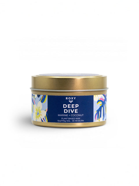 The Roxy Deep Dive Palm Tin Candle features a gold tin with blue and white floral design. Enjoy creamy coconut and marine scents from plant-based wax, with up to 45 hours of burn time.
