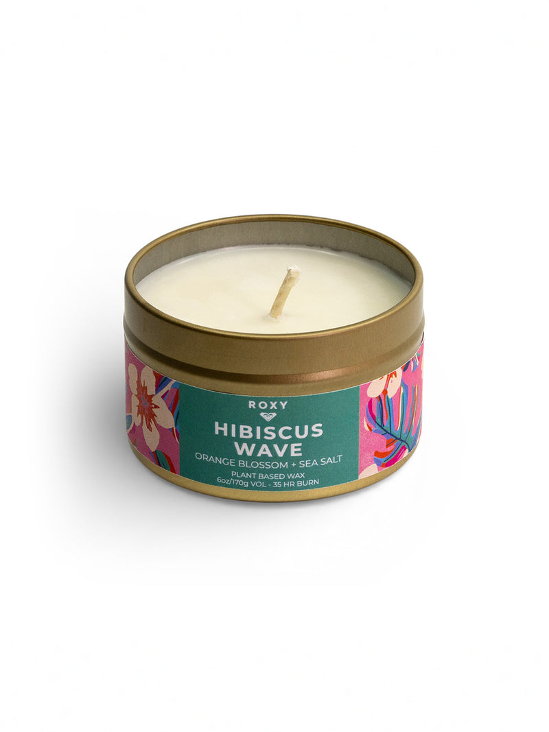 The Roxy Hibiscus Wave Palm Tin Candle is a round metal tin with a single wick and vibrant floral design. The label features "Orange Blossom + Sea Salt," evoking a tropical scent.