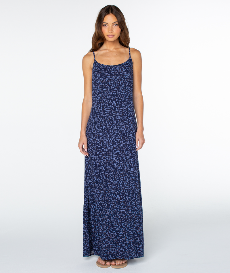 Woman wearing the Roxy Skylar Maxi Dress in Dutch Blue Margarita Ditsy, featuring thin straps and a square neckline, standing against a plain white background and facing forward.