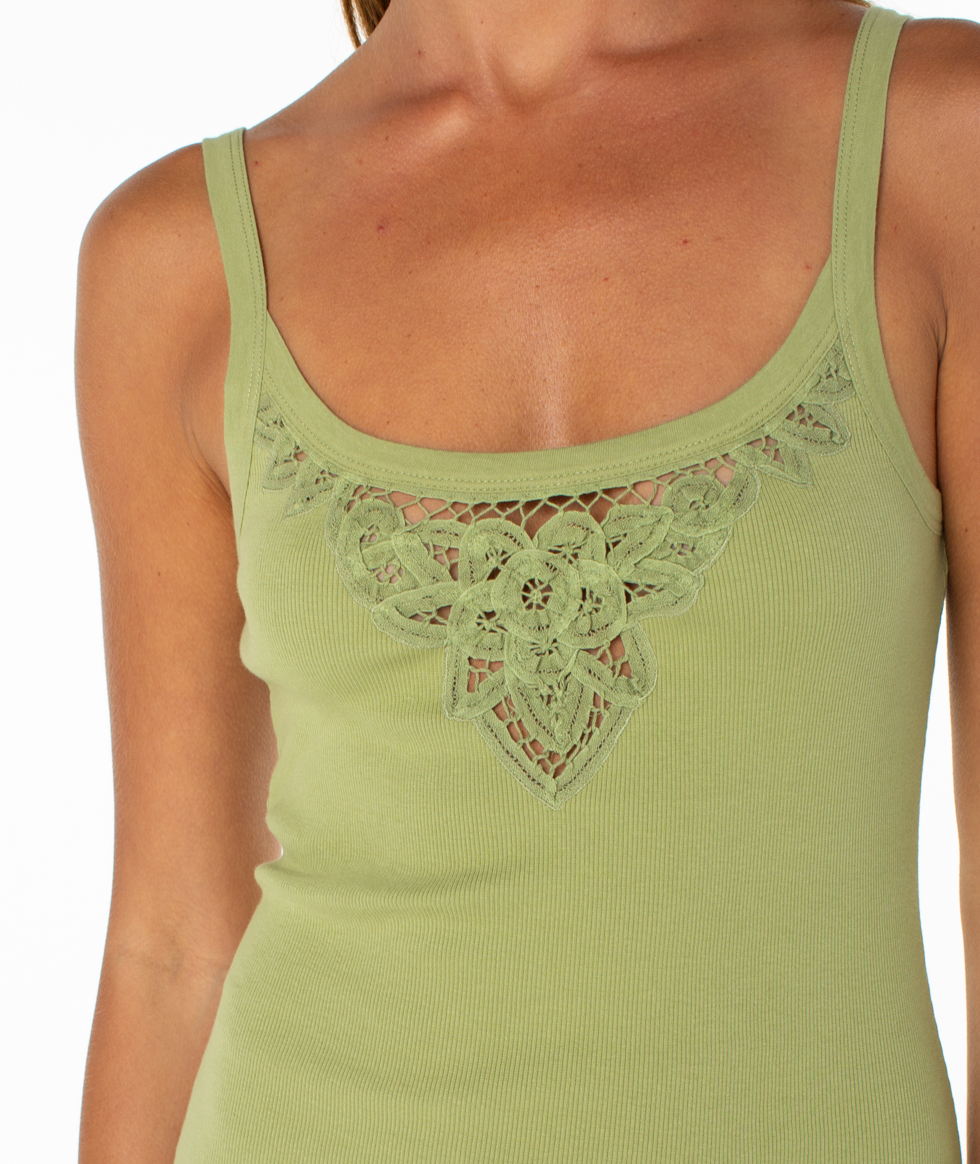 Close-up of a person wearing the Wanderlust Mini Dress by Roxy, a light green cotton blend featuring decorative lace floral detail at the neckline. The background is plain white.