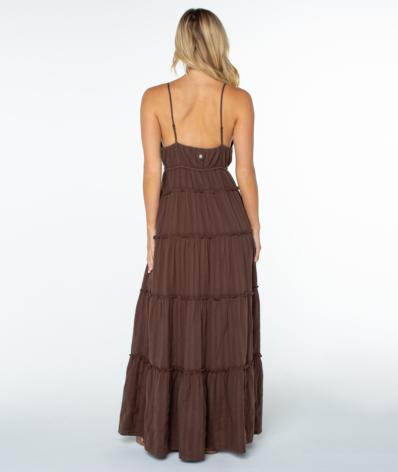 A woman with long blonde hair wears the Roxy Starlight Maxi Dress, featuring a tiered skirt and thin straps, standing with her back to the camera against a plain white background.