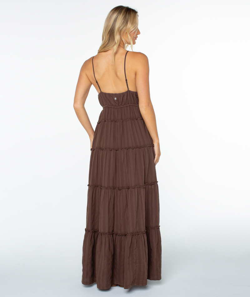 A woman with blonde hair stands facing away in the Roxy Starlight Maxi Dress, featuring thin straps and a sleeveless, tiered skirt against a plain white background.