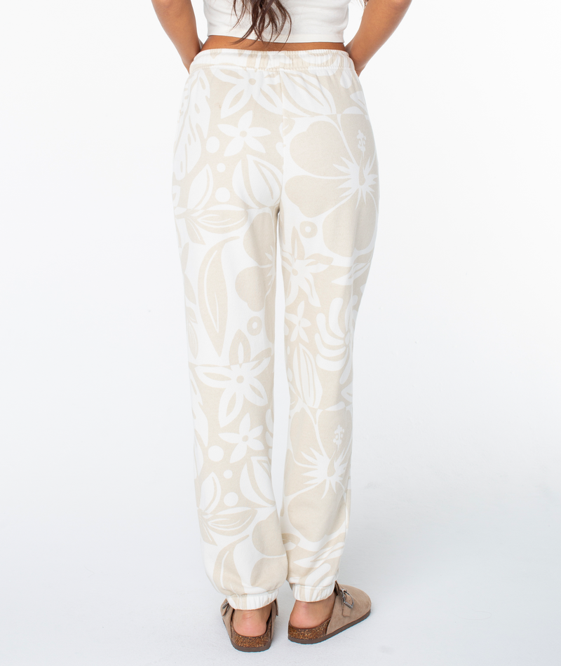 Rear view of high-waisted Roxy Maile Printed Pant featuring a cream and white bold floral print and cinched cuffs.