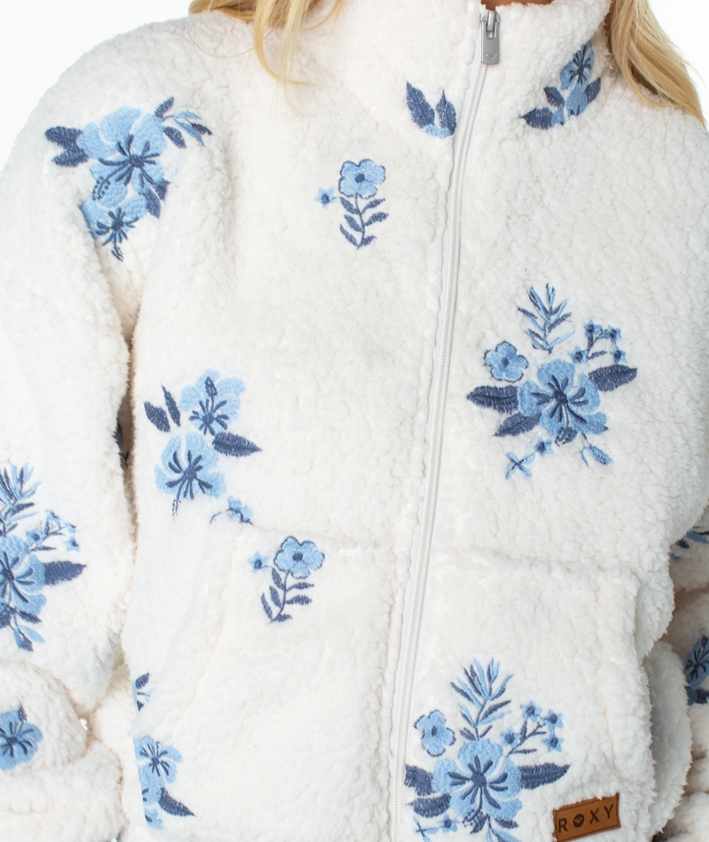 Roxy Cold Surf Fleece Top in a cream-colored, relaxed-fit zip-up style with blue floral embroidery.
