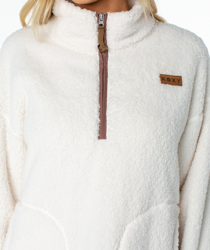 Roxy Cozy Day Fleece Top in off-white, featuring a cozy mock neck, brown zipper placket, and a rectangular logo patch on the chest.