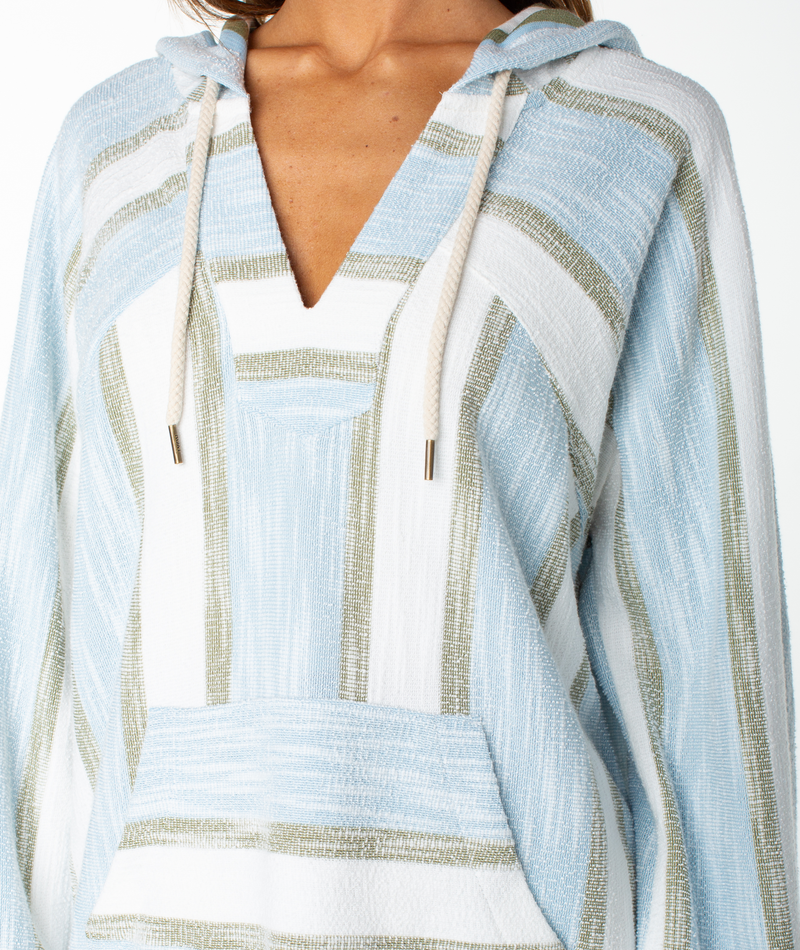Model shown from shoulders to waist wearing the Wild And Free Top by Roxy, featuring light blue, white, and beige stripes. This V-neck cotton blend terry top has drawstrings, a front pocket, and a textured appearance—perfect for channeling coastal vibes.