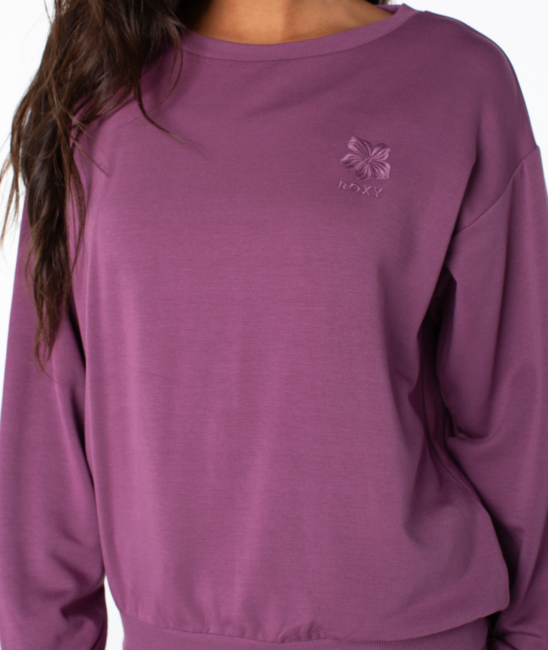 A plum-colored Roxy Surfing By Moonlight Top, featuring a long-sleeve crewneck design with a small embroidered flower logo on the chest.