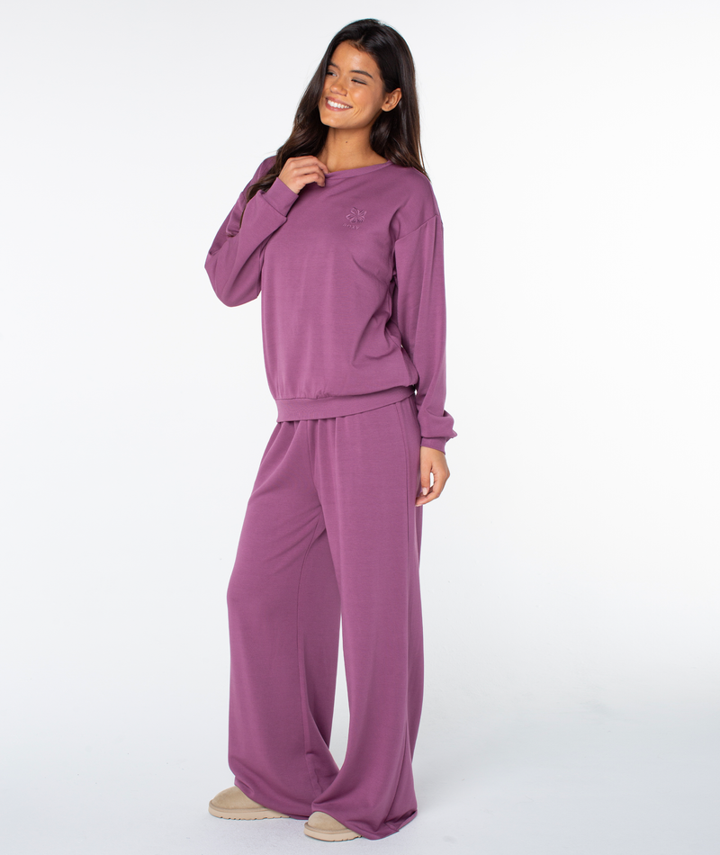 A woman smiles while wearing a matching Tulipwood Hibiscus Emb Surfing By Moonlight Top and wide-leg trousers.