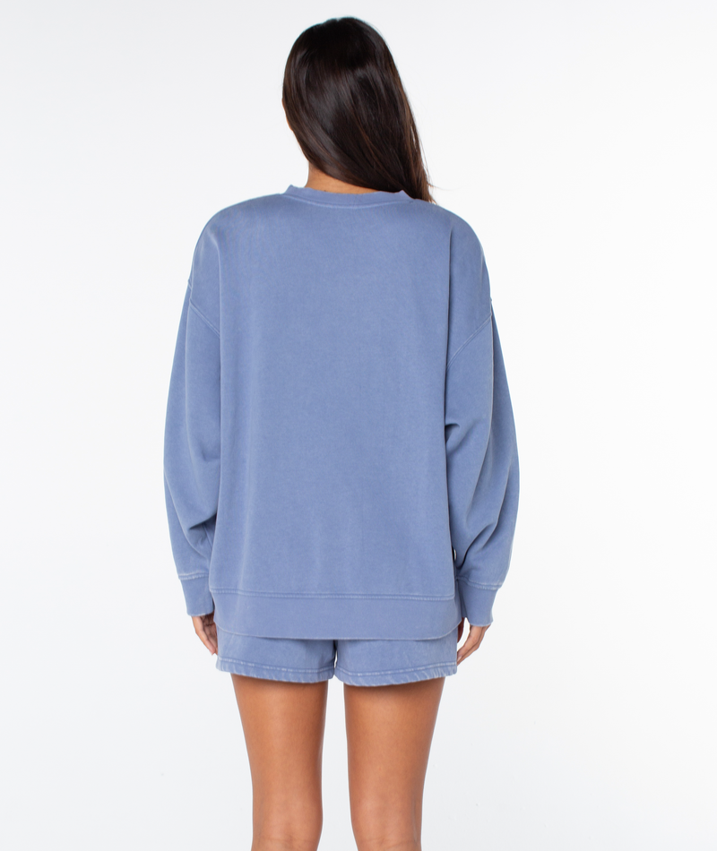 A woman with long brown hair stands facing away, wearing the Roxy Hazy Daze Patch Top and matching shorts against a plain white background.
