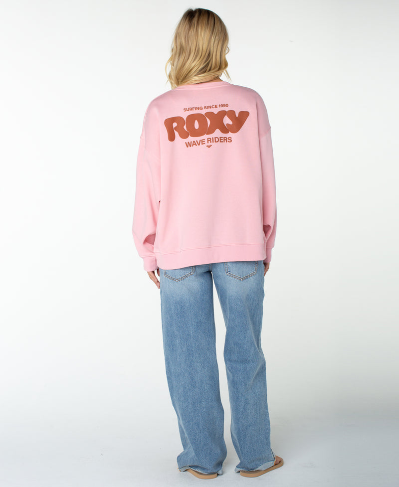 A person wearing the Roxy Morning Stroll Top in pink and light blue jeans stands barefoot, facing away from the camera against a plain white background.