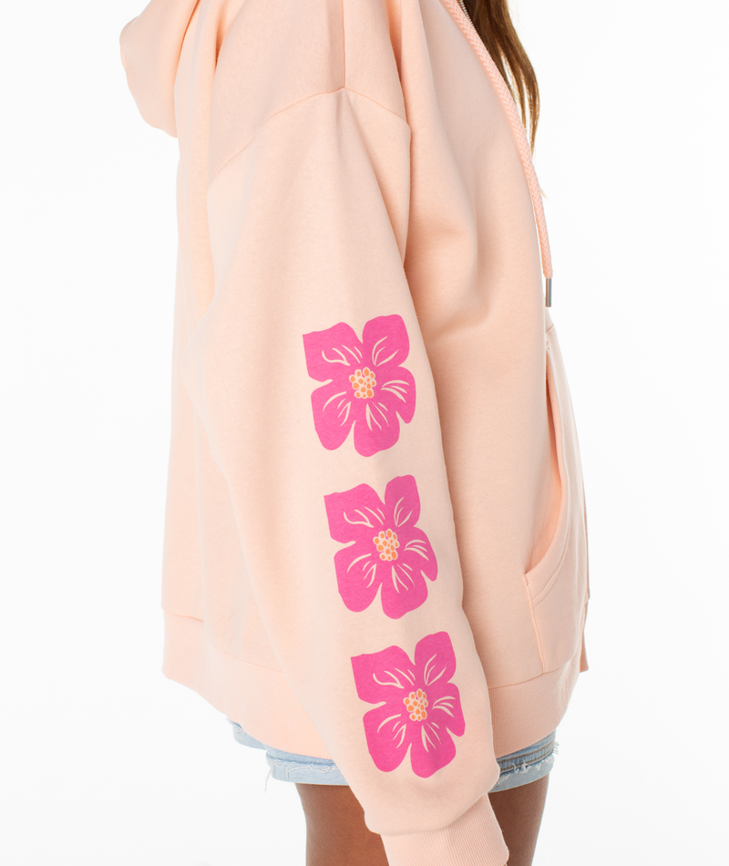 A person models the Roxy Evening Lineup Hoodie in light peach, featuring three pink flowers on the sleeve. The side view highlights the sleeve and pocket against a white background.