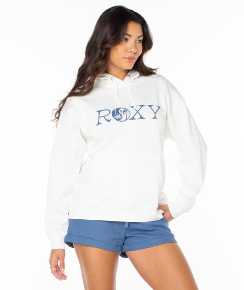 Woman wearing a white hoodie with 'Roxy' logo and blue shorts on a white background