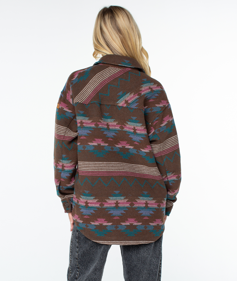 Back view of an oversized Roxy Overlander Jacket with a colorful, geometric southwestern pattern, worn with dark gray jeans.