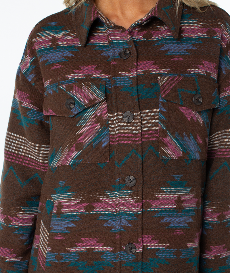 Roxy Overlander jacket in an oversized brown button-front style featuring a colorful geometric Southwestern-inspired print, two chest pockets, and a cozy sherpa lining.