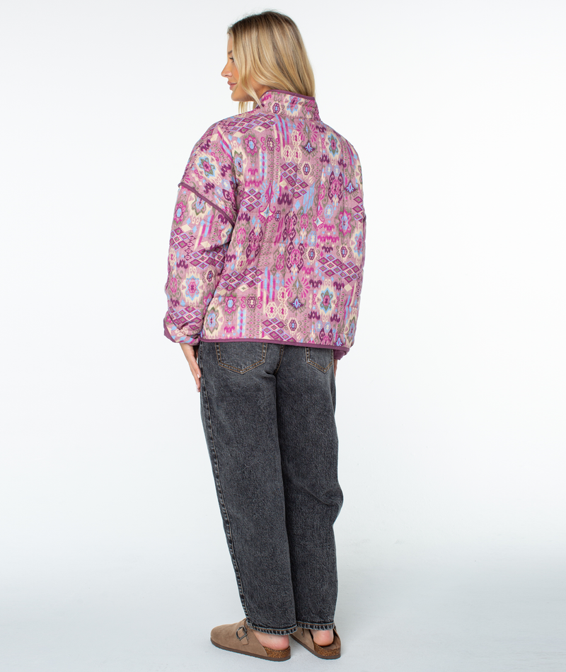 A person wearing a relaxed fit Roxy Solana jacket with a geometric print and charcoal gray jeans.
