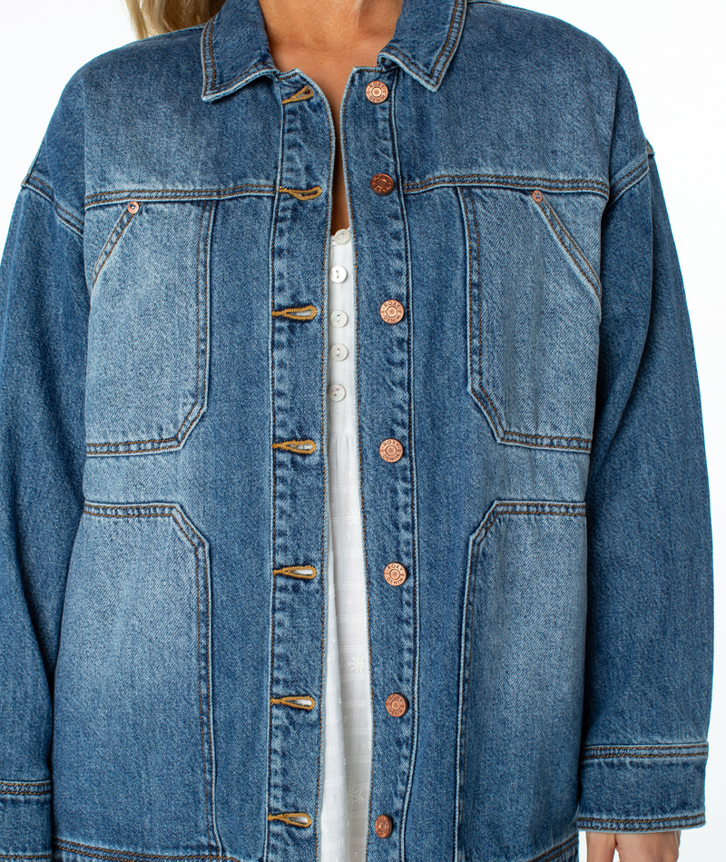 Roxy Lost Treasure jacket in oversized blue denim with two chest pockets and metal buttons worn over a white shirt.
