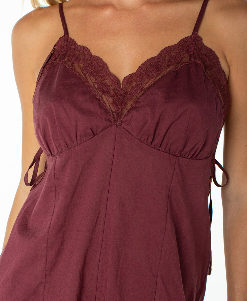 A close-up of a woman wearing the Roxy Moonrise Romper—an effortless wardrobe staple with delicate lace trim and slender straps that elevates any look.