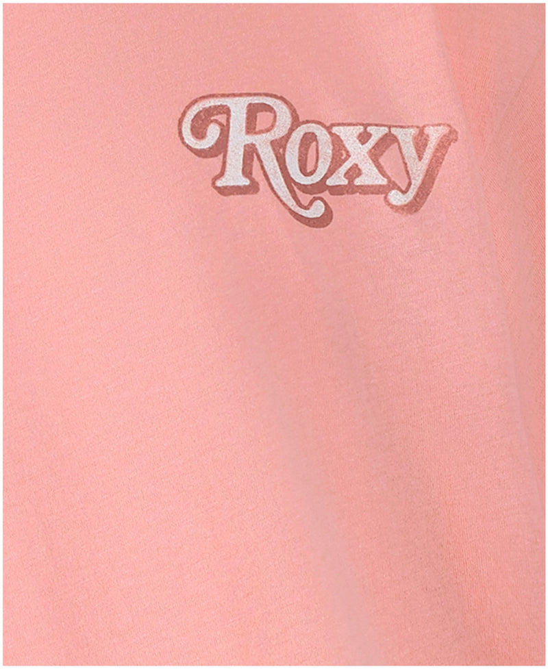 Close-up of the Girls' Wavy Daze Oversized Tee by Roxy in light pink, featuring "Roxy" in white with a pink outline on the upper left side—ideal for beachy, coastal style.
