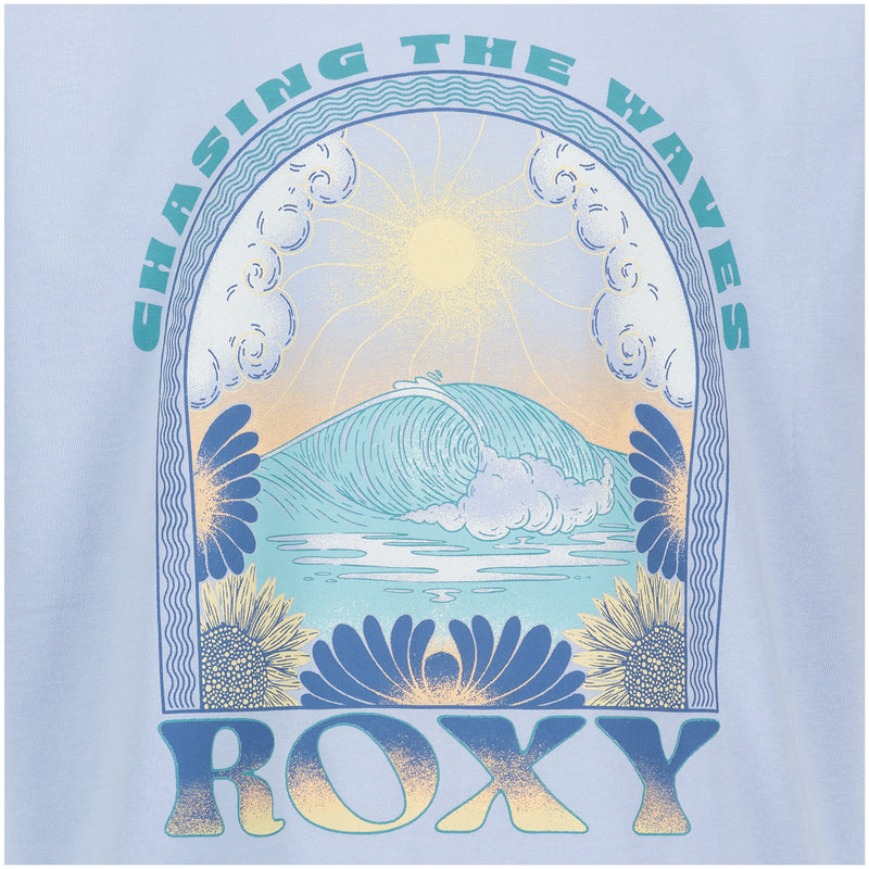 The Girls' Chasing Waves Oversized Tee by Roxy displays "CHASING THE WAVES" above a sun, curling wave, clouds, and sunflowers, with bold Roxy lettering at the bottom—all printed on soft cotton jersey.