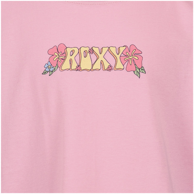 A close-up of the Girls' Sun Chaser Oversized Tee by Roxy, a pink cotton jersey boyfriend shirt with "ROXY" in yellow stylized letters, surrounded by pink and blue flowers and signature Roxy graphics.
