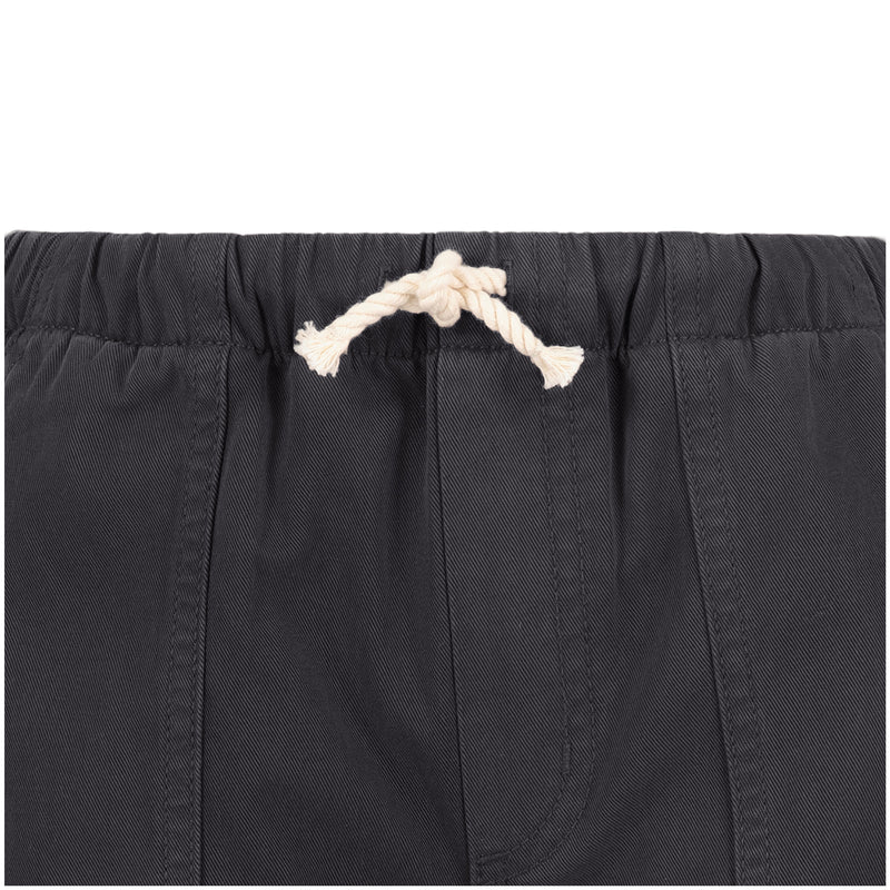 Close-up of the waistband on Roxy's Girls' Precious Cargo Pant in dark gray, featuring an off-white drawstring knot, visible stitching, and gathered elastic. Made from durable cotton canvas twill.