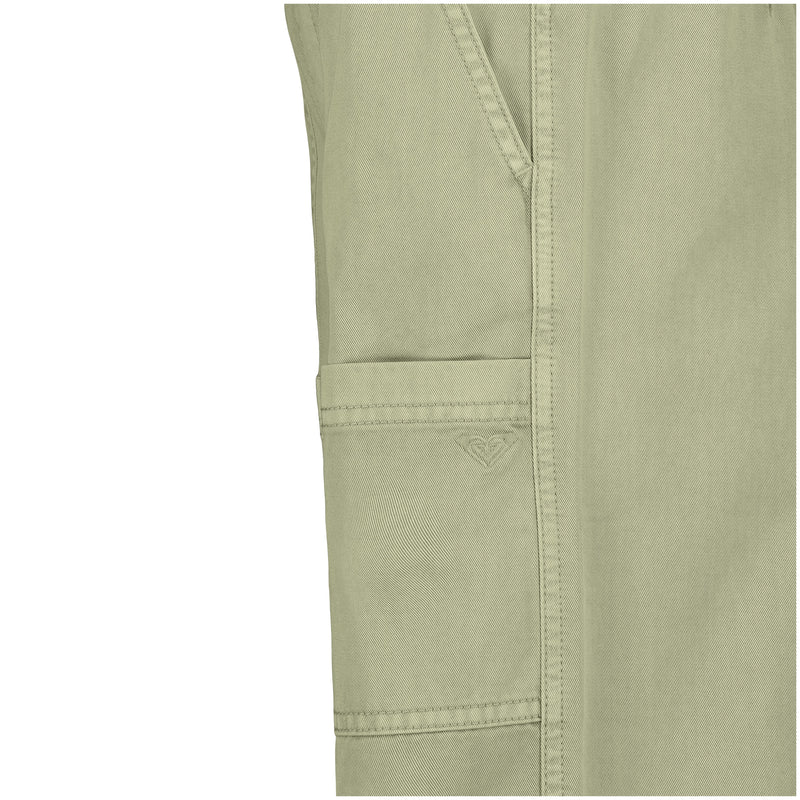 Close-up of Roxy Girls' Precious Cargo Pant in light olive-green cotton canvas twill, relaxed fit with a pocket featuring subtle stitching and small heart embroidery; edge of another pocket and seam details highlight classic cargo styling.