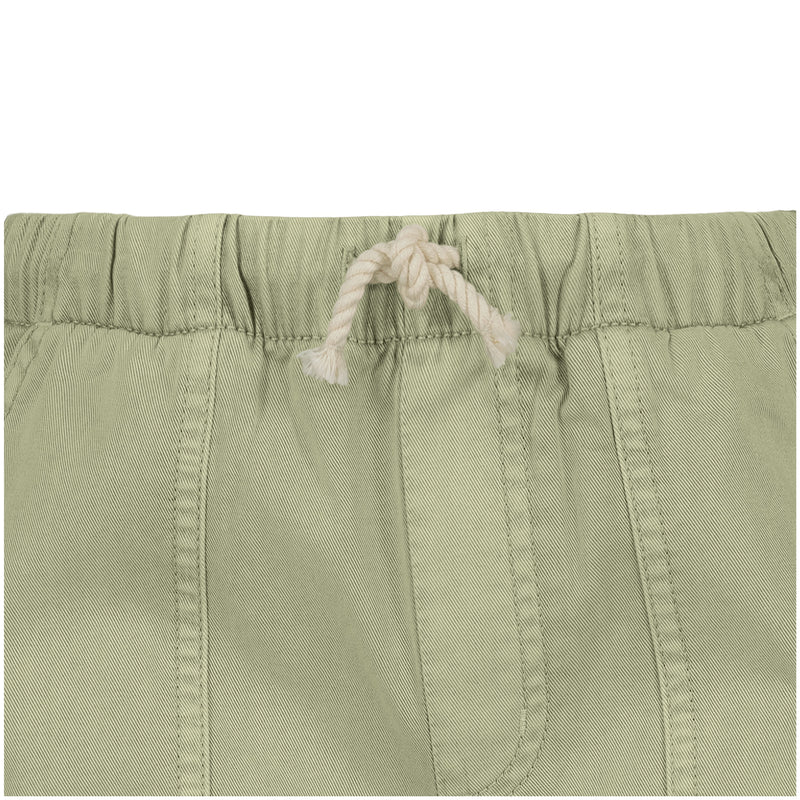 Close-up of Roxy Girls' Precious Cargo Pant in light green, featuring a relaxed fit with elastic waistband, white braided drawstring tied in a knot, and visible seam stitching.