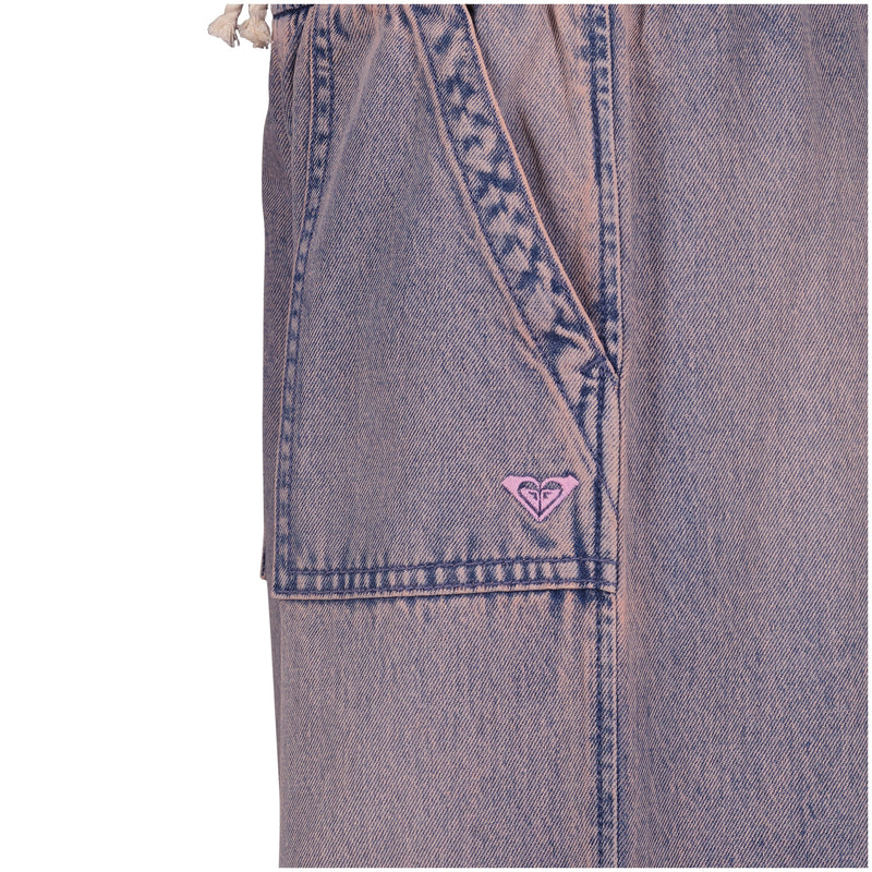 Close-up of the Roxy Girls' Denim Himalayan Pant in light purple-pink cotton denim, featuring a front pocket, stitched details, and a small pink embroidered logo by the seam.