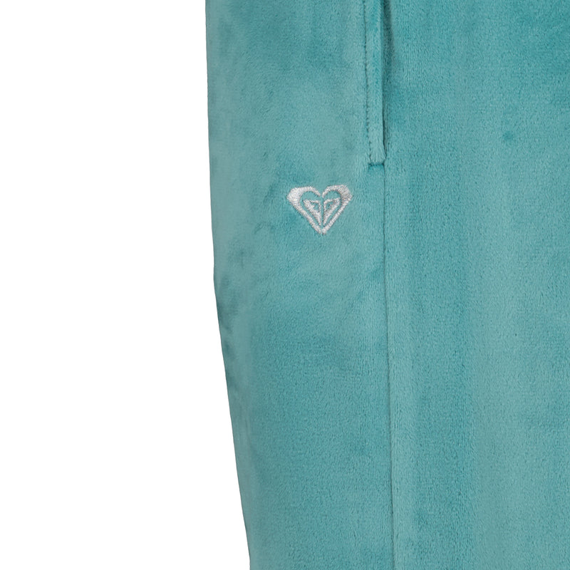 Close-up of Roxy Girls’ Velour Pant in teal, featuring a relaxed fit and an embroidered silver heart logo below the pocket.