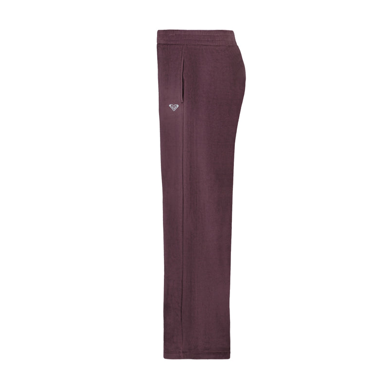 Side view of Roxy Girls’ Velour Pant in purple, featuring an elastic waistband, side pockets, and a small heart-shaped logo on the hip.