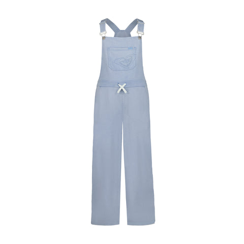 The Girls' Coastline Overall by Roxy features light blue, soft cotton-poly French terry, adjustable straps, a front chest pocket with stitched heart, a white waist bow, and straight full-length legs.