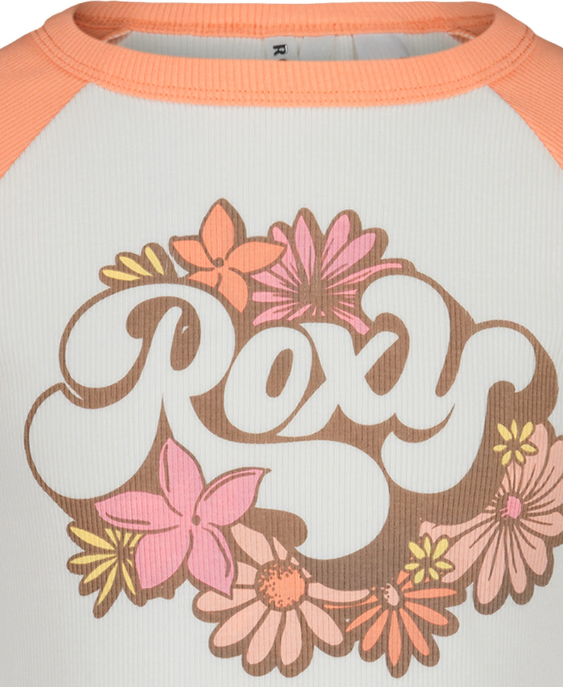 Close-up of the Roxy Girls Stay Groovy Baby Tee, a raglan t-shirt with peach sleeves and white body. “Roxy” is printed in bold letters, surrounded by pink, orange, and yellow flowers for a vibrant floral graphic look.