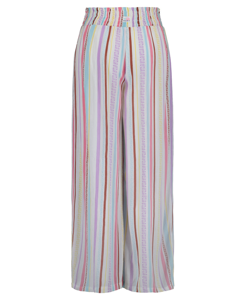 The Roxy Girls' Bali Stripe Pant features pastel pink, yellow, blue, purple, and white vertical stripes with a high waist, wide-leg cut, and elastic waistband—ideal beach pants for sunny days.