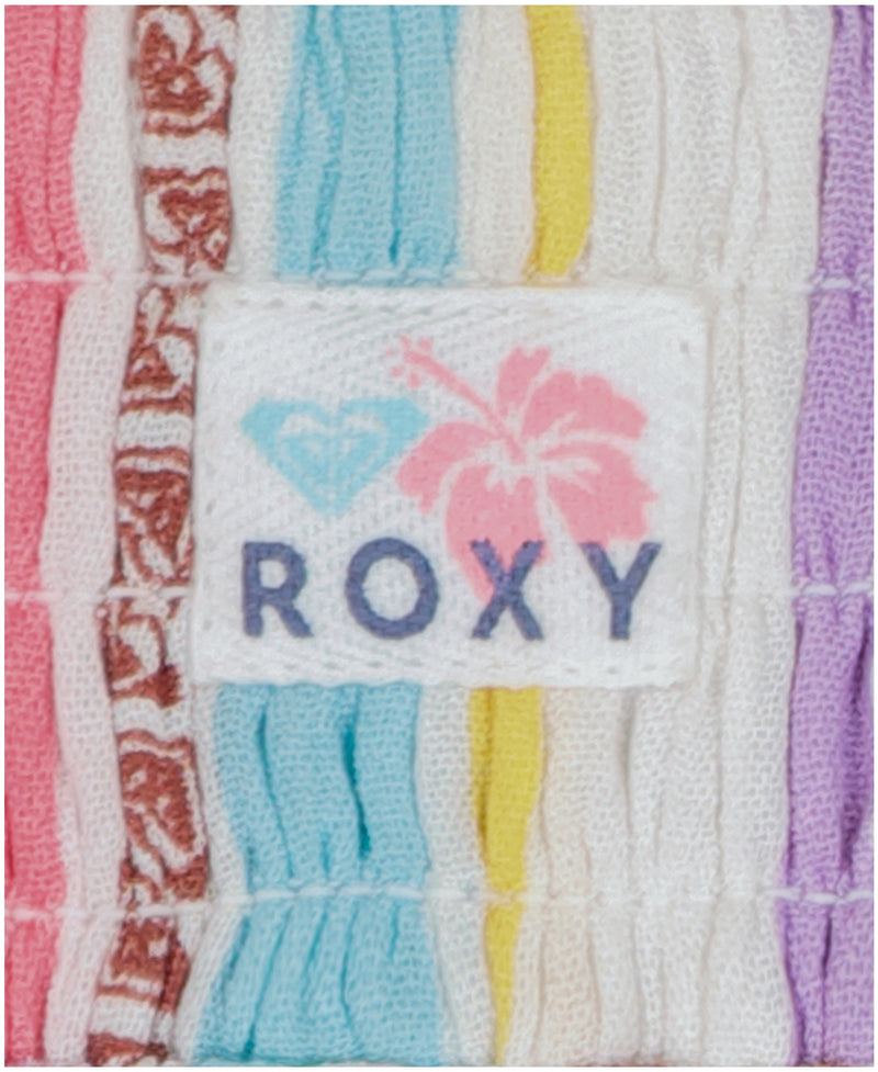 A close-up of the fabric label with "Roxy," a pink hibiscus, and a turquoise heart logo is sewn onto the pastel-striped Girls' Bali Stripe Pant by Roxy—showcasing its fun, colorful style.