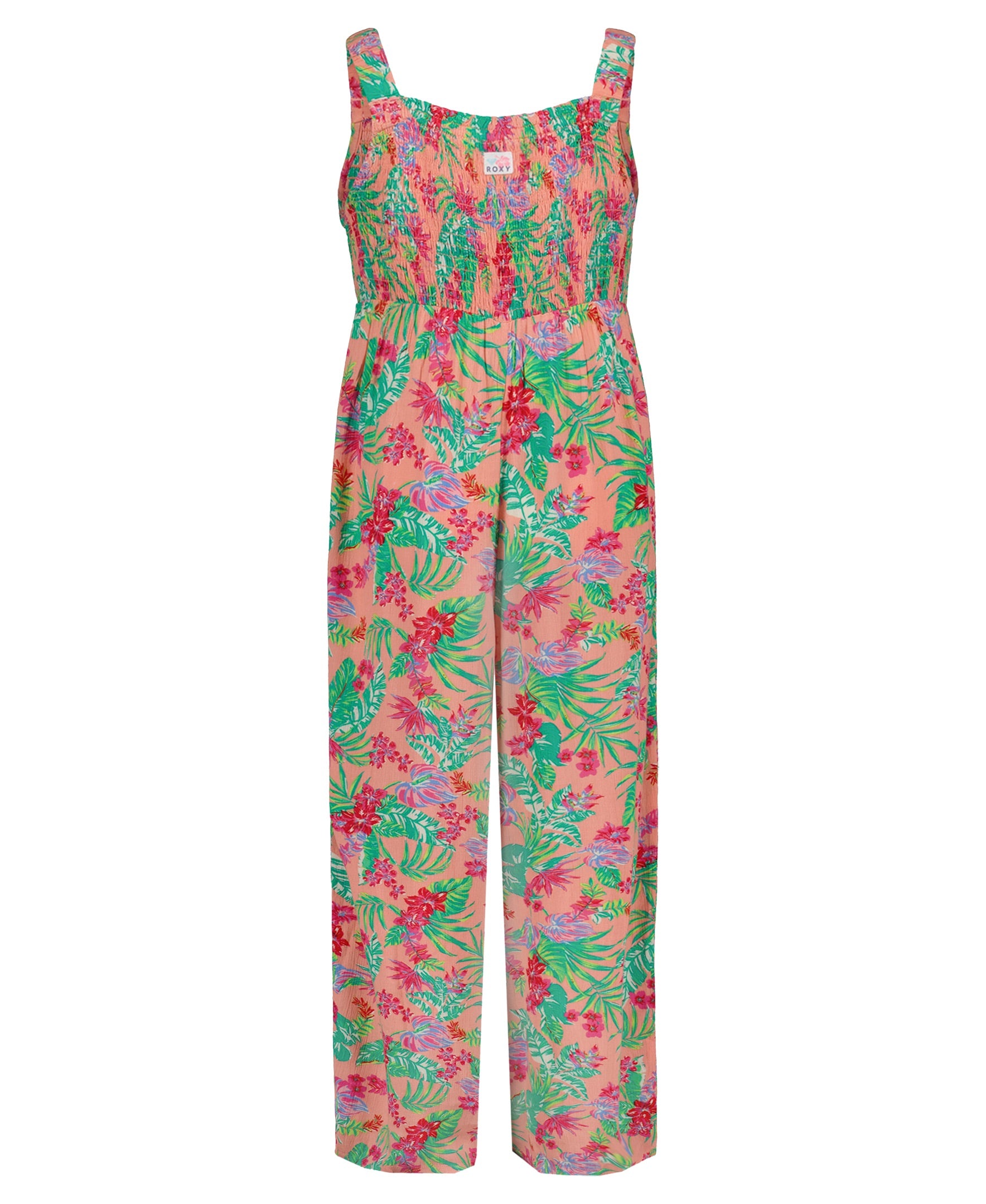 The Girls' Coastal Breeze Jumpsuit by Roxy is a sleeveless viscose jumpsuit with a smocked bodice, wide legs, and a vibrant floral and leafy print in pink, green, red, and purple on a light pink background.