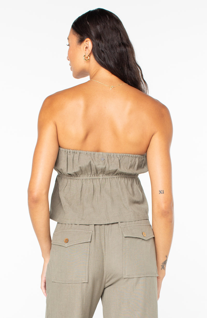 Back view of a person wearing a Roxy Iyla Top, an olive green, strapless, gathered-waist tube top, with matching pants.