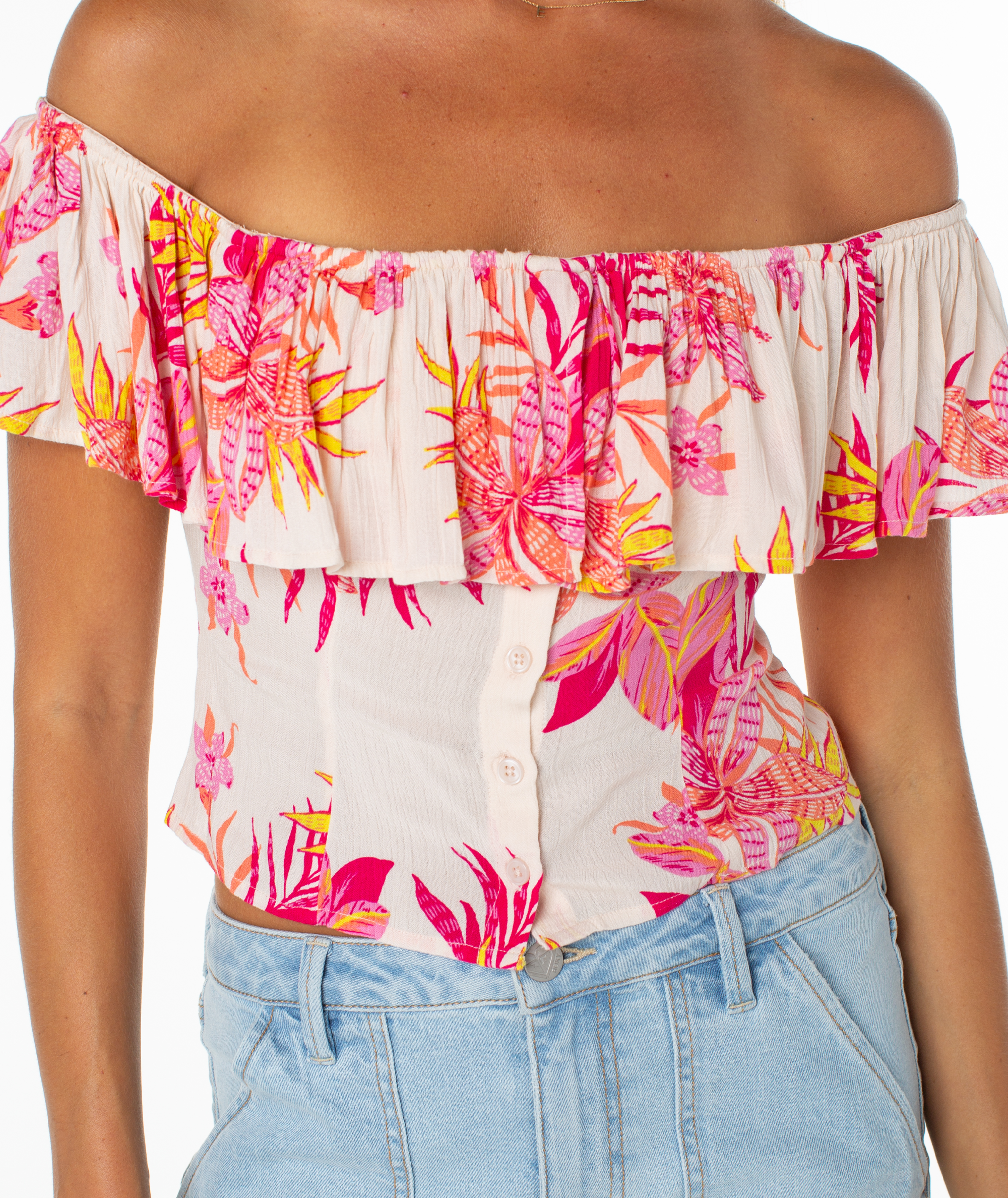 The Roxy Clear Sky Top features an off-the-shoulder cream design with a pink, orange, and yellow floral print—perfectly paired with light wash jeans for an easy, feminine style.