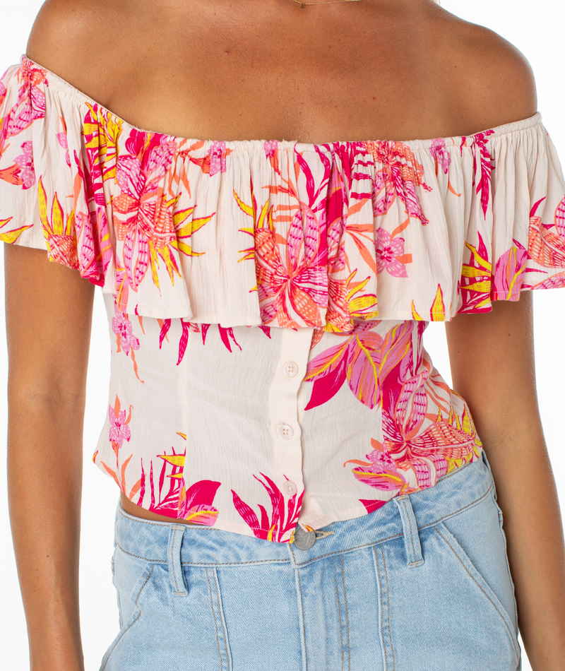 The Roxy Clear Sky Top features an off-the-shoulder cream design with a pink, orange, and yellow floral print—perfectly paired with light wash jeans for an easy, feminine style.