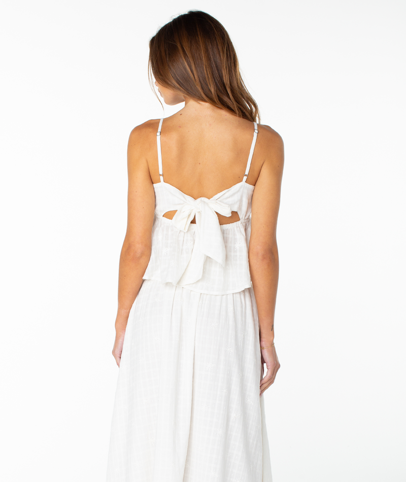 A woman wearing the Roxy Pierside Top faces away from the camera, standing against a white background—a look as effortlessly chic as your favorite relaxed tank.