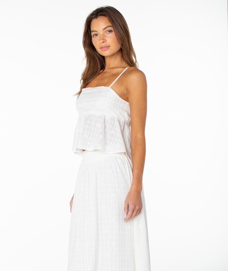 A woman wearing the Roxy Pierside Top, styled with a matching skirt, stands against a plain white background and looks at the camera with a relaxed expression.