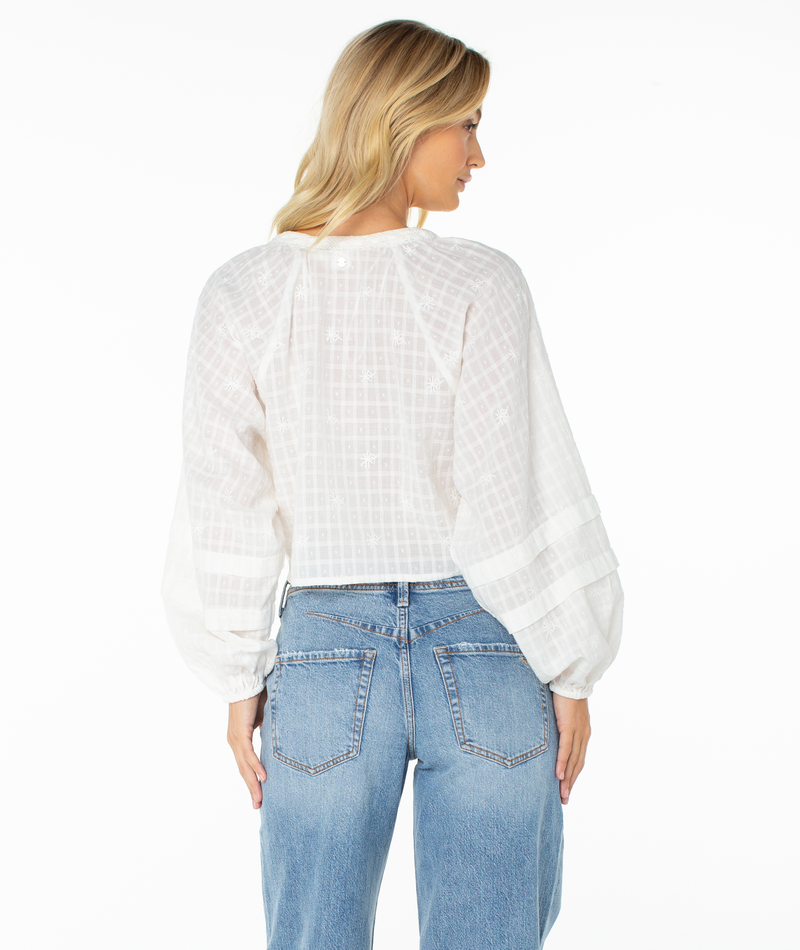 A woman with blonde hair wears the Monterey Top by Roxy with oversized sleeves and light blue high-waisted jeans, viewed from the back against a plain white background.