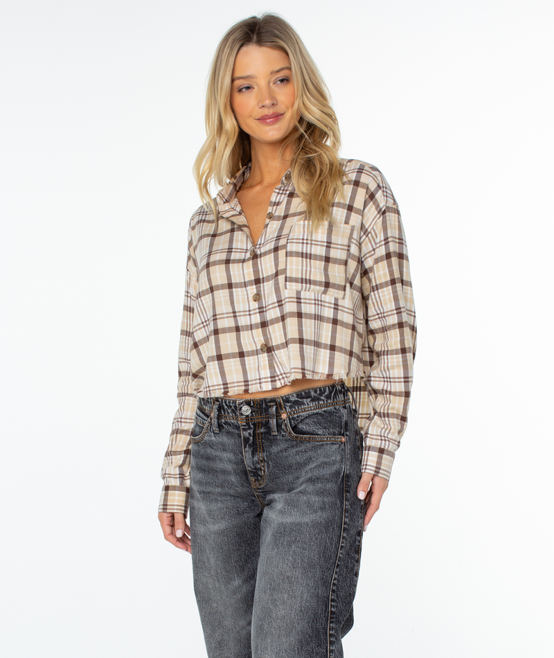 Woman with long blonde hair wears the Roxy Rockford Top in Pebble Tartan Plaid and faded black jeans, standing against a plain white background.