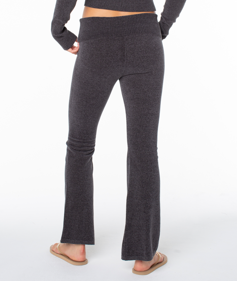 A person from the back wearing Roxy Couch Surf Pants in dark gray, featuring a wide-leg fit and a ribbed foldover waistband.
