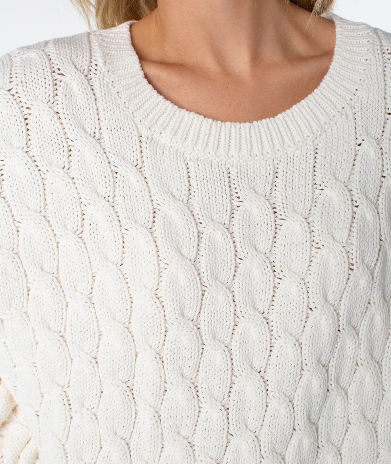 Close-up of the white, chunky cable-knit Cold Front Cable Sweater by Roxy.