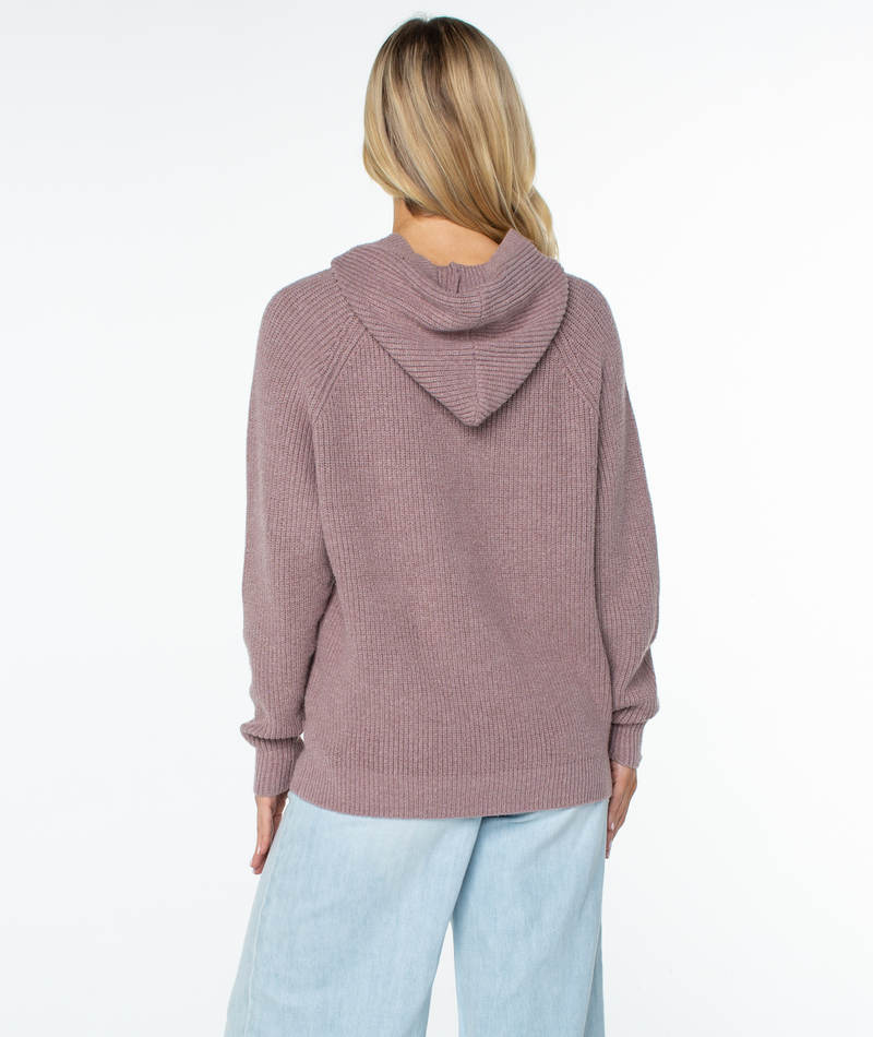 Back view of a mauve ribbed knit Roxy Cozy Town sweater worn with light blue jeans, serving as a perfect winter staple.